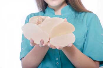 female-holds-breast-implant